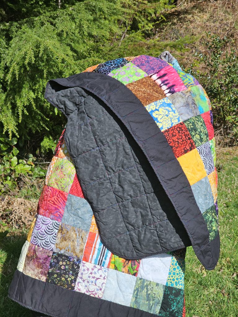 Batik Patchwork Queen Sized Quilt held